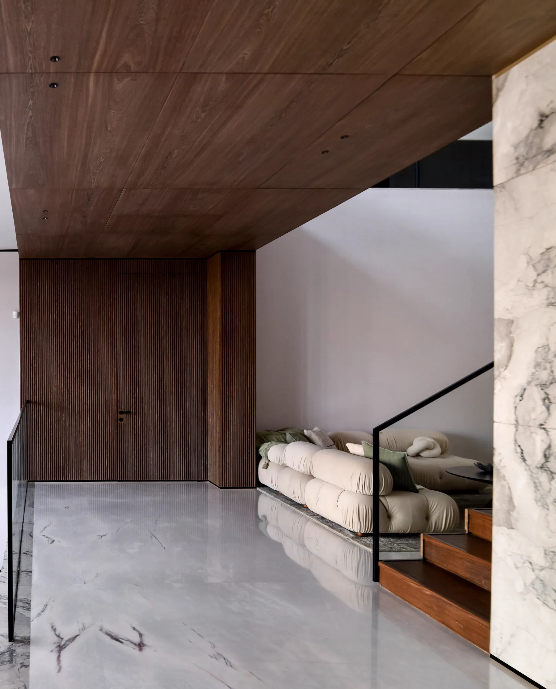 Interior of a modern coastal residence, walnut paneling and marble staircase